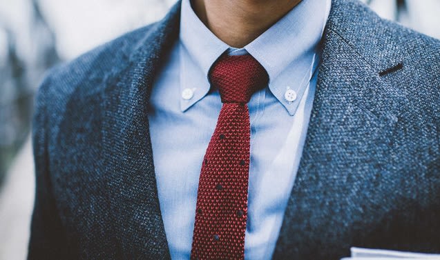 A Man Wearing A Blue Button Down Shirt With A Red Tie