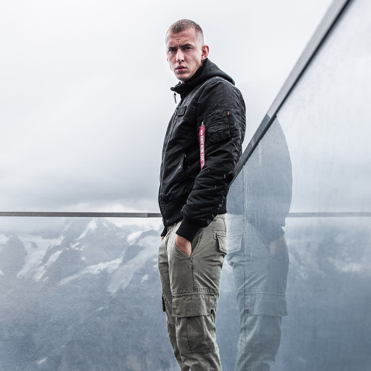 a man stares into the camera wearing Alpha Industries