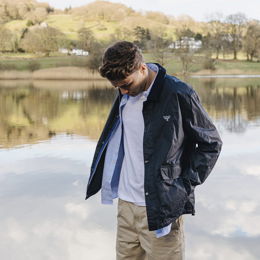 Man in Barbour Beacon jacket standing next to a lake