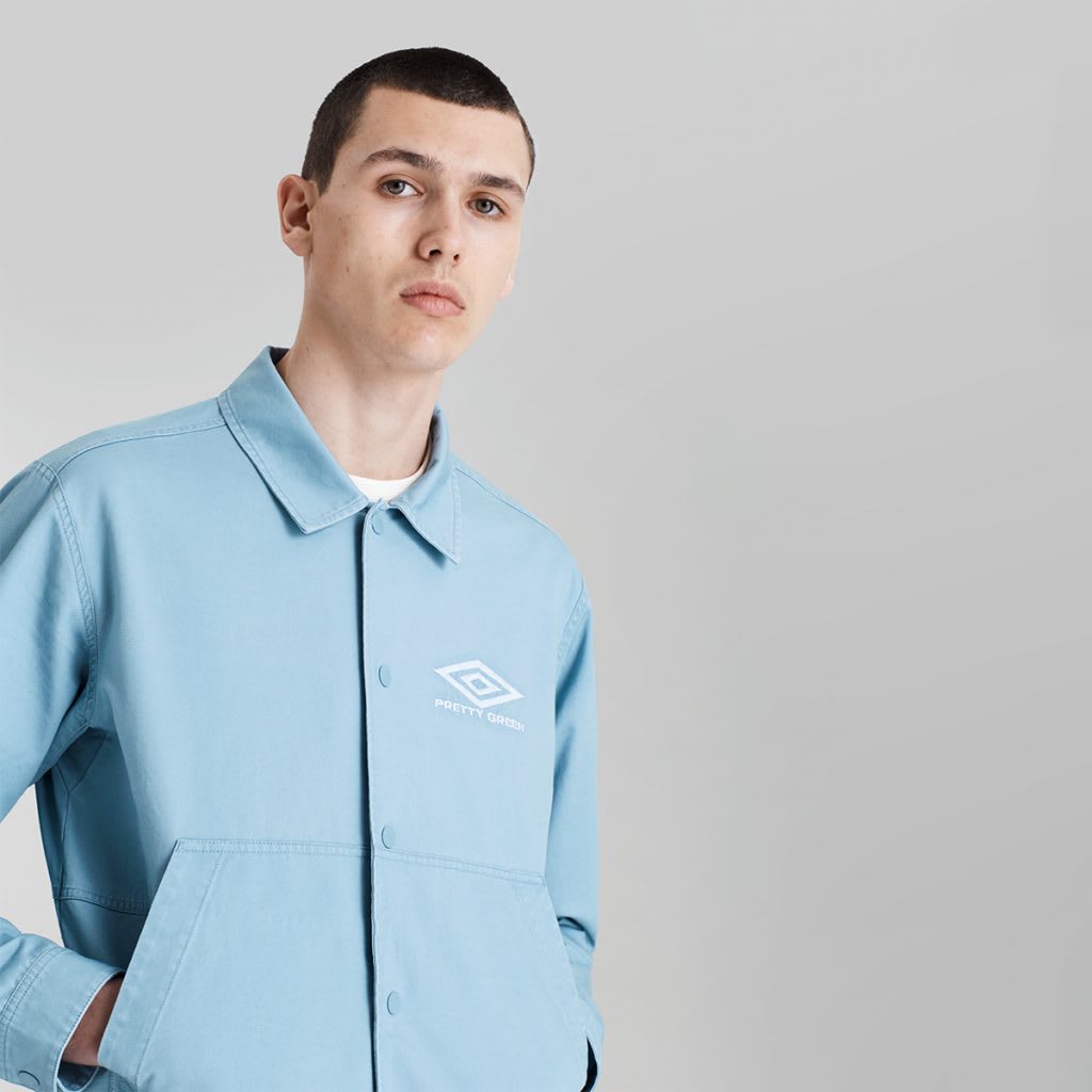 Young man wearing Pretty Green x Umbro shirt in light blue