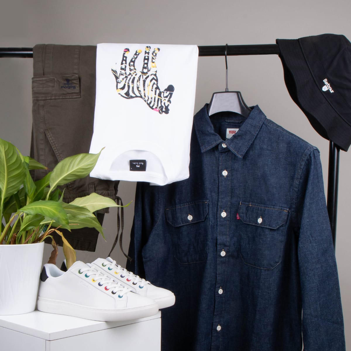 A capsule wardrobe hanging from a clothes rack including a shirt, T-shirt and trousers
