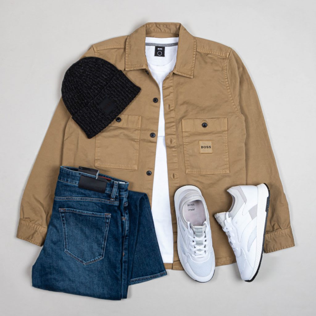 A capsule outfit layout including a coat, jeans, shoes and a hat.