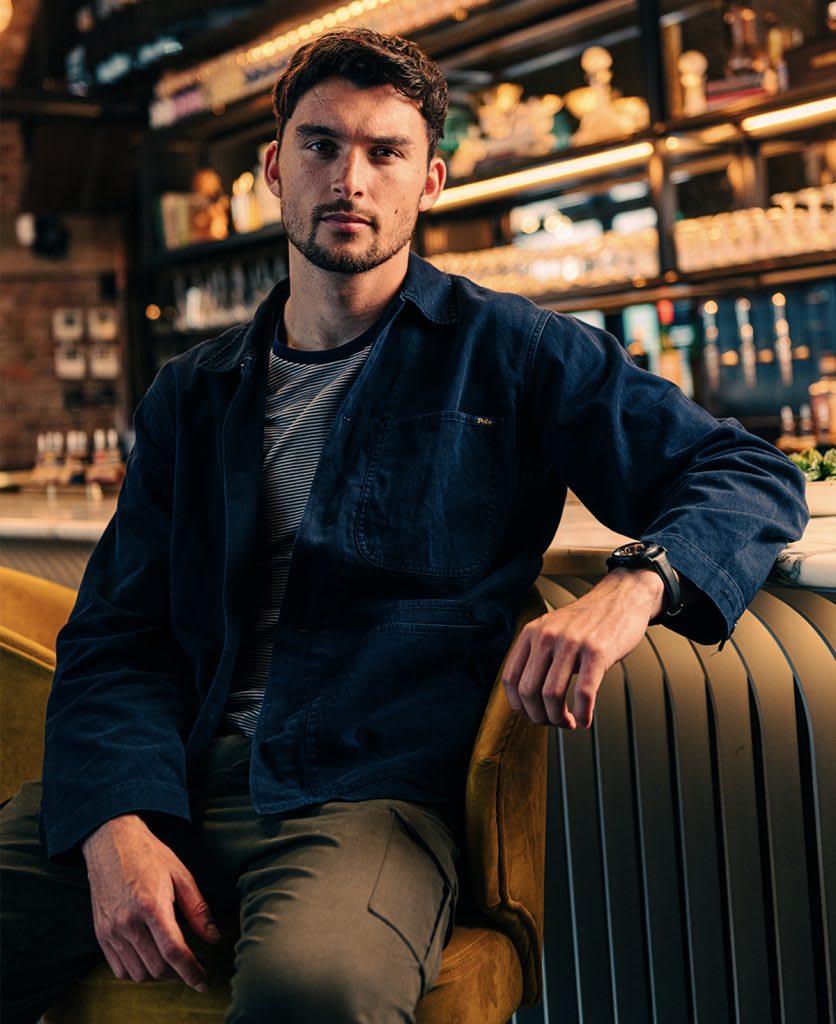 A man sitting in a bar wearing Ralph Lauren clothing