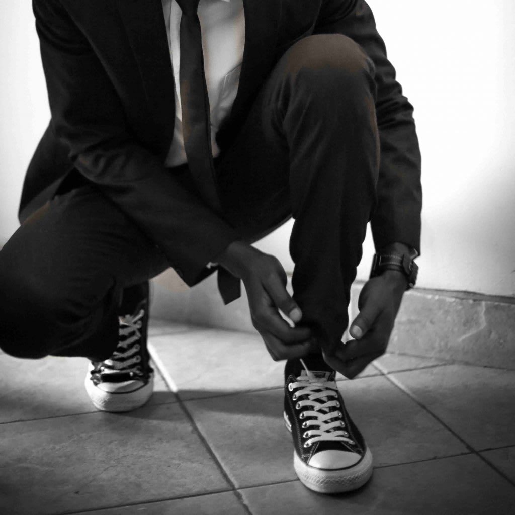 A man in a suit ties his shoelaces