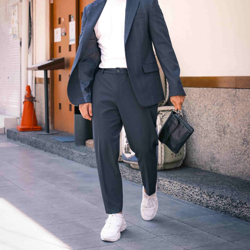 A man in the street wearing trainers with a suit