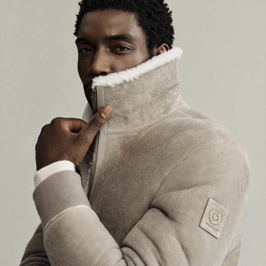 A man turning up the collar on his Belstaff jacket