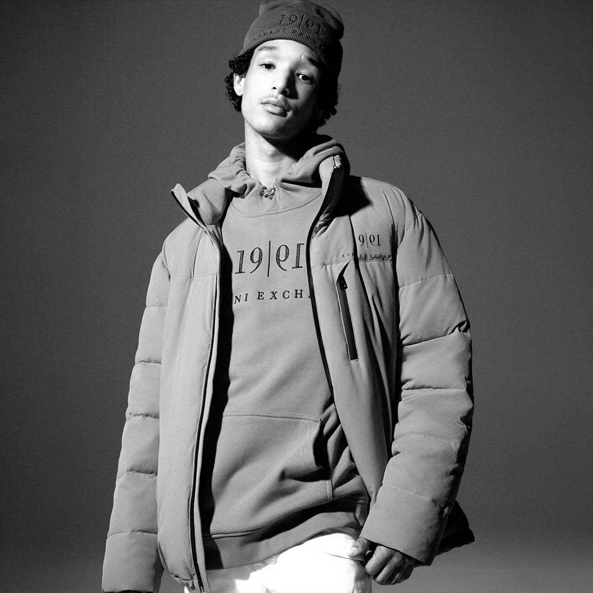A man standing up in Armani Exchange sweatshirt and jacket