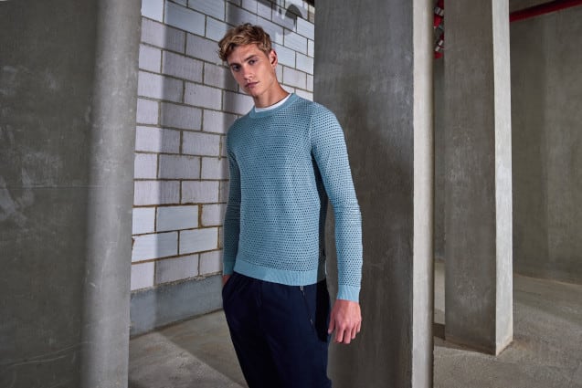 Man wearing blue jumper and black trousers
