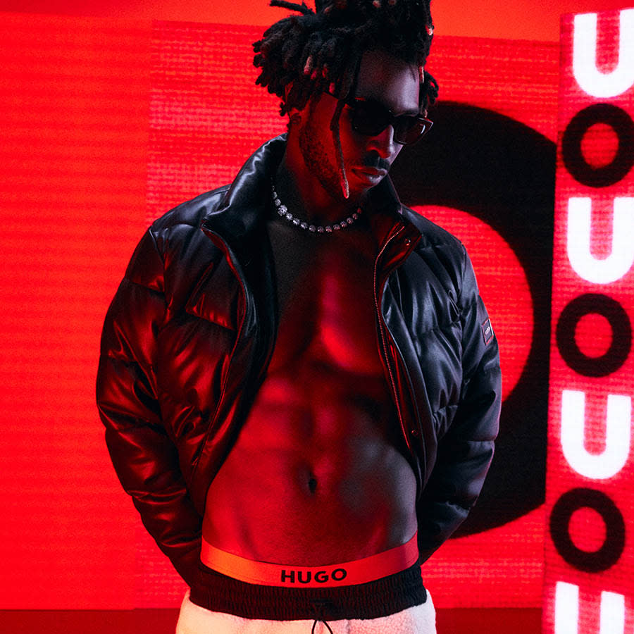HUGO branding on red black and white background with a model wearing a jacket