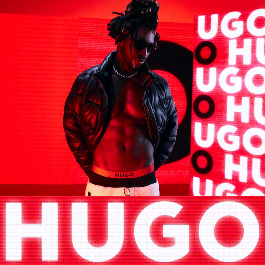 A man against a red background with HUGO branding