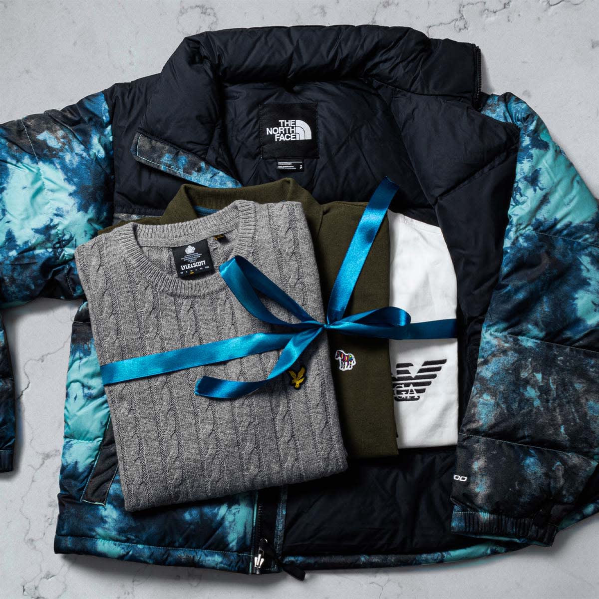 A selection of designer clothes wrapped in a ribbon