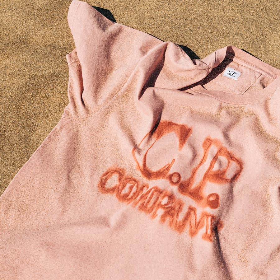 Beachwear by CP Company laying in the sand