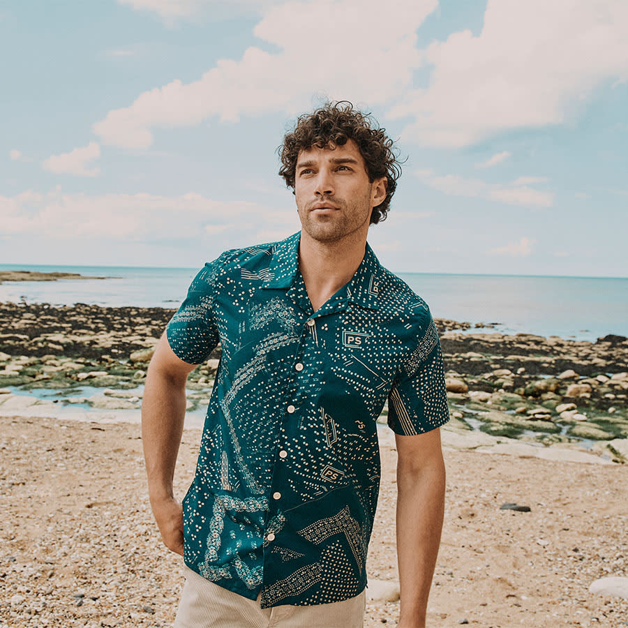A man in an untucked shirt by the seaside