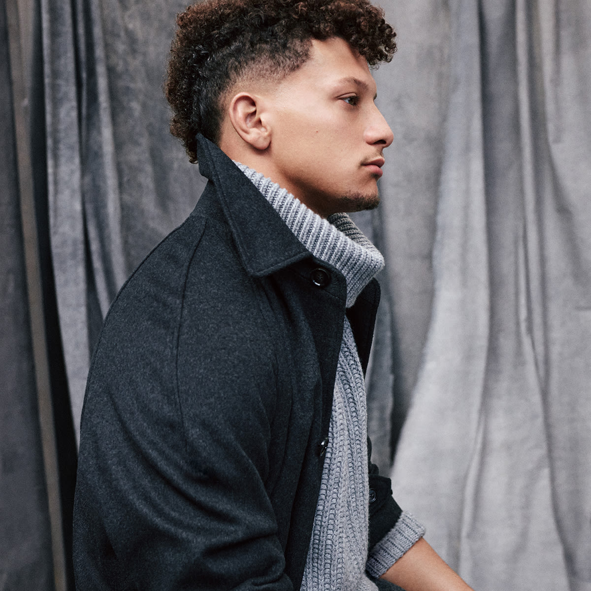 A man wearing a BOSS jumper and jacket