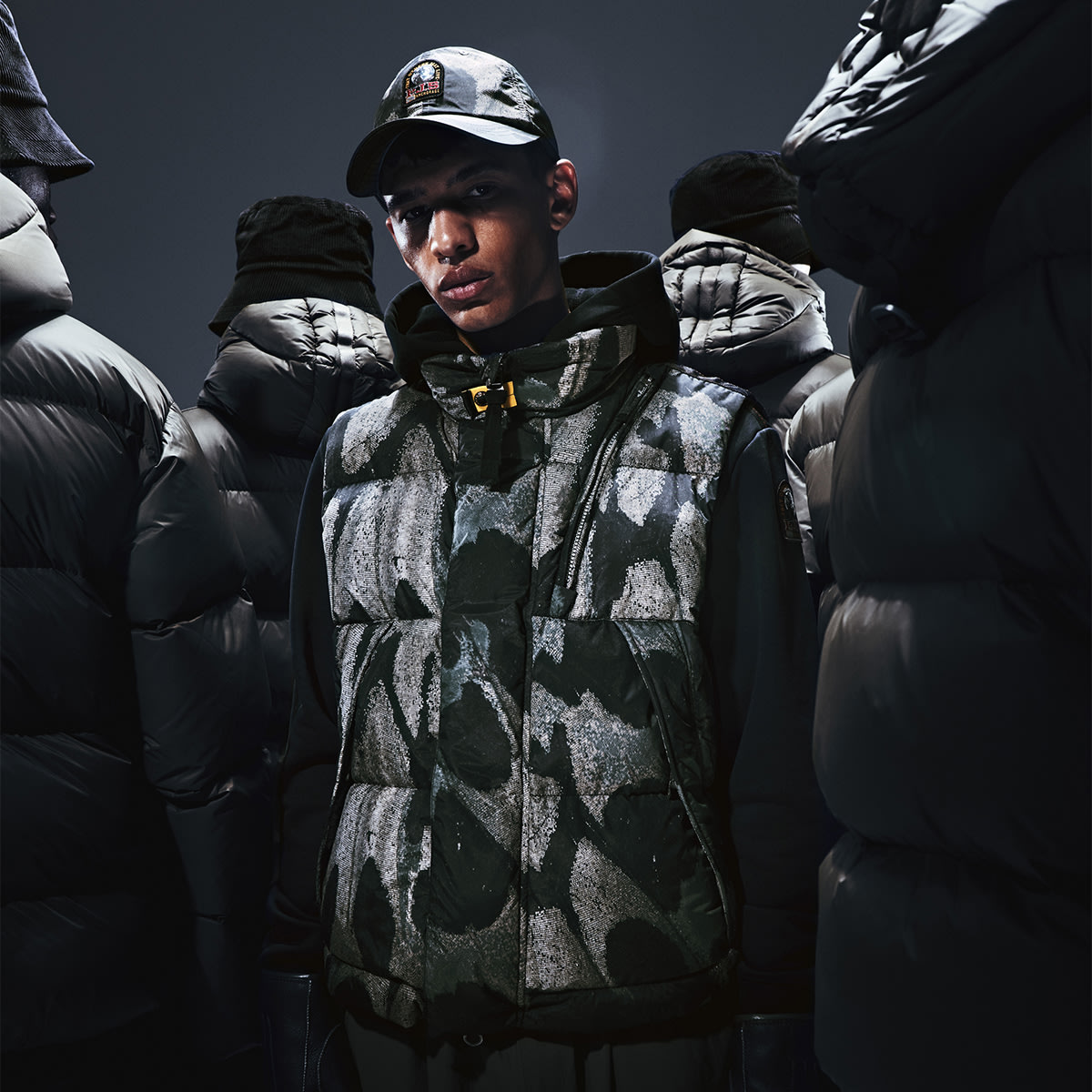 A man standing in a crowd wearing a Parajumpers jacket