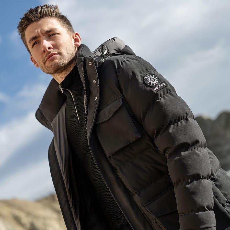 A man wearing a Sandbanks jacket outside