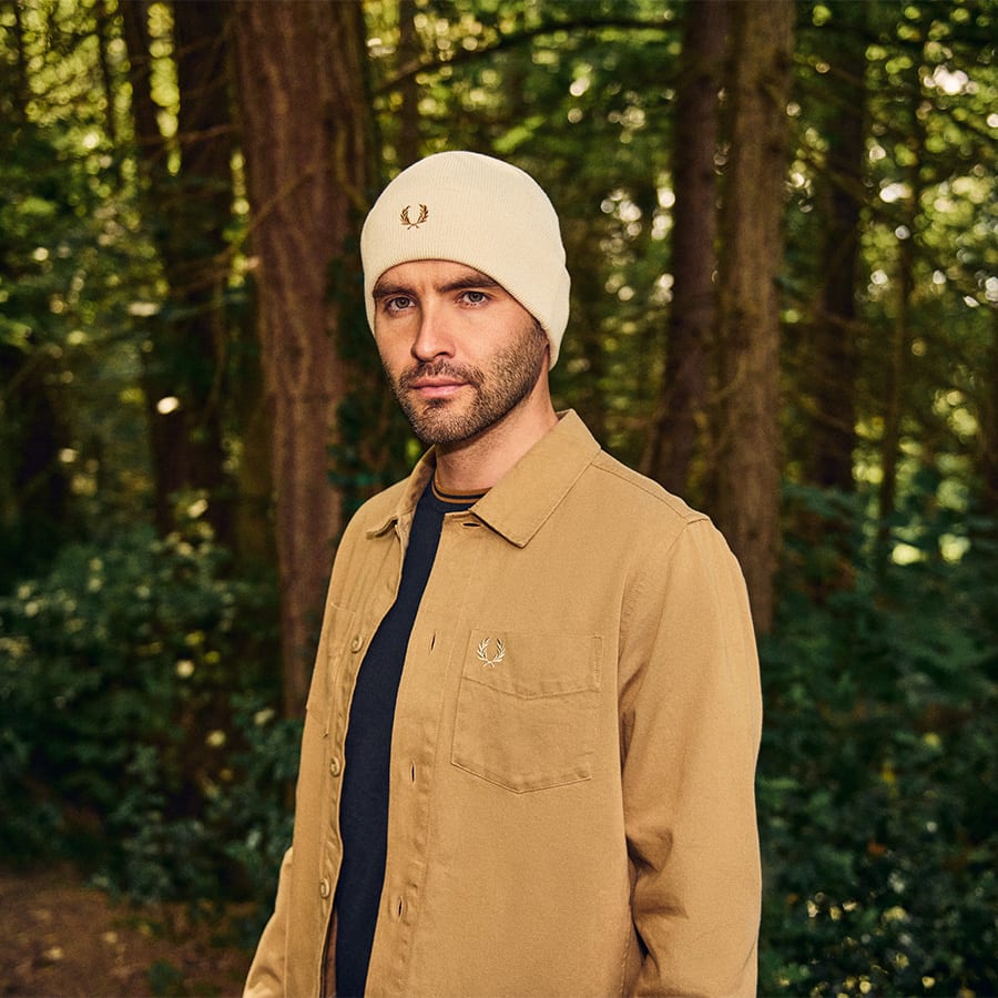 A man in the forest dressed in Fred Perry clothing