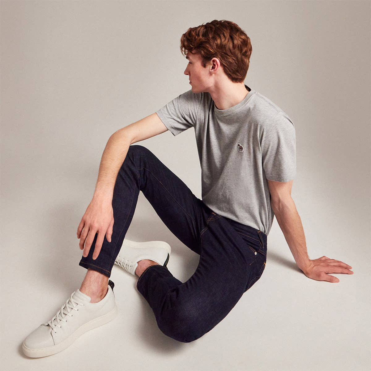 A sitting man wearing Paul Smith clothing