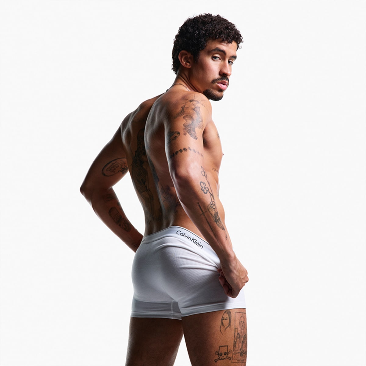 A man facing away from the camera wearing white Calvin Klein underwear