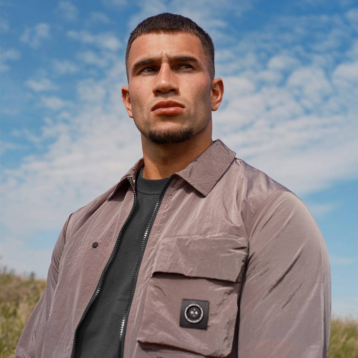 A man wearing Marshall Artist clothing in front of a spring sky