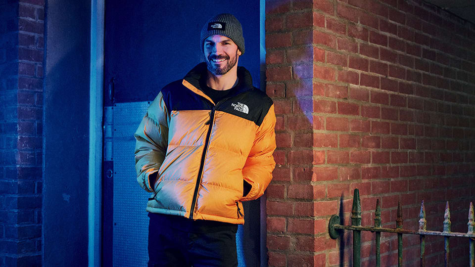 A smiling man dressed in designer clothing