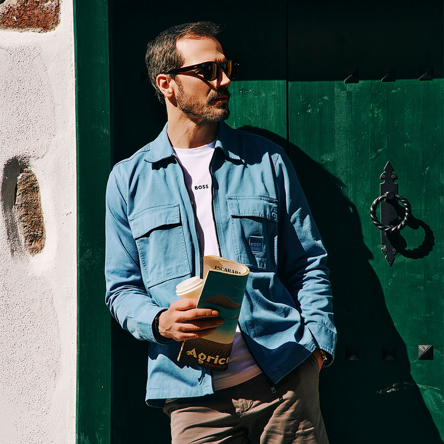 A man dressed in BOSS clothing leaning in a doorway