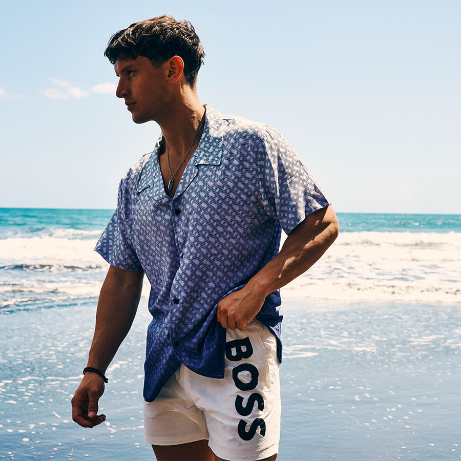 A man wearing BOSS standing on the shoreline