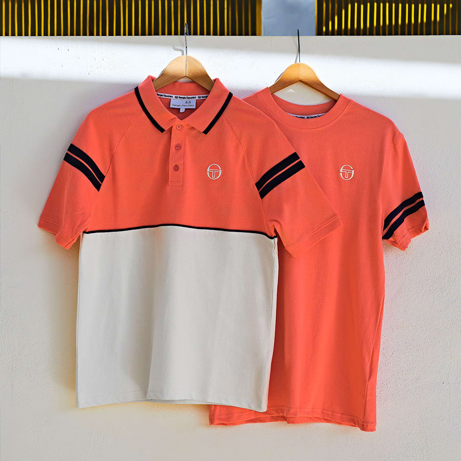 Orange T-shirts hanging on a wall
