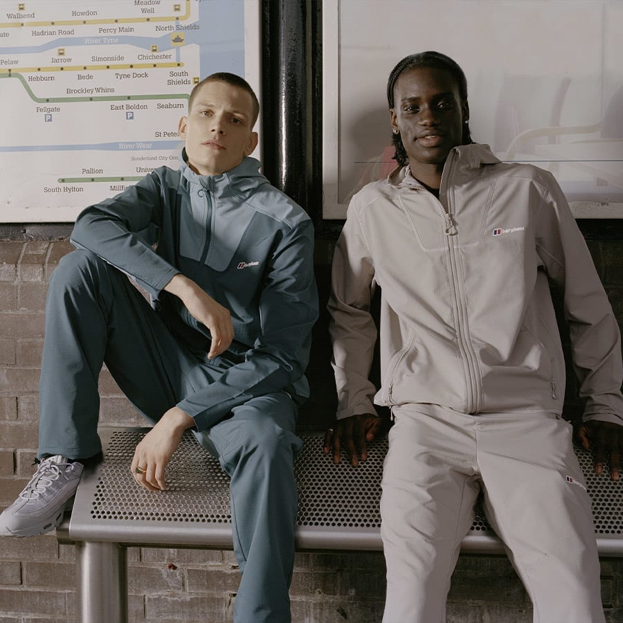 Two young men wearing Berghaus tracksuits sitting in a bus stop