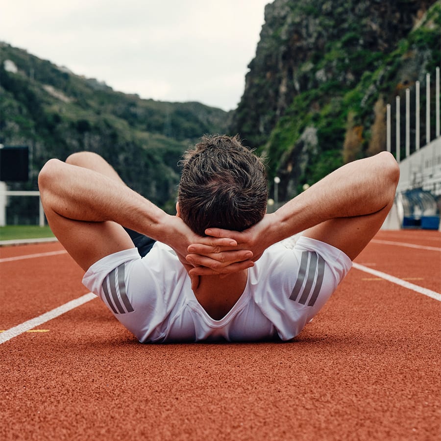 A man stretching on a running track
