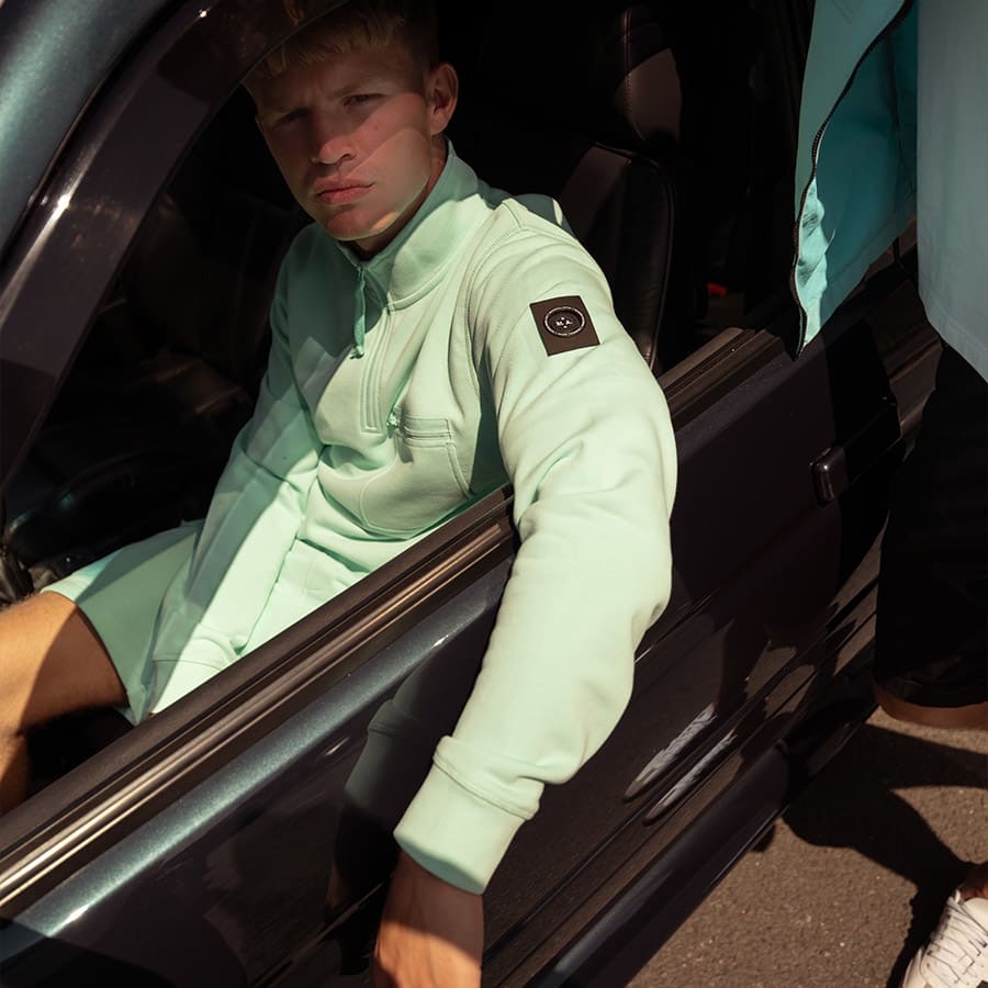 A man sitting in a car wearing a Marshall Artist jacket