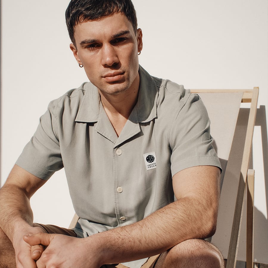A man sitting on a deckchair wearing a polo shirt