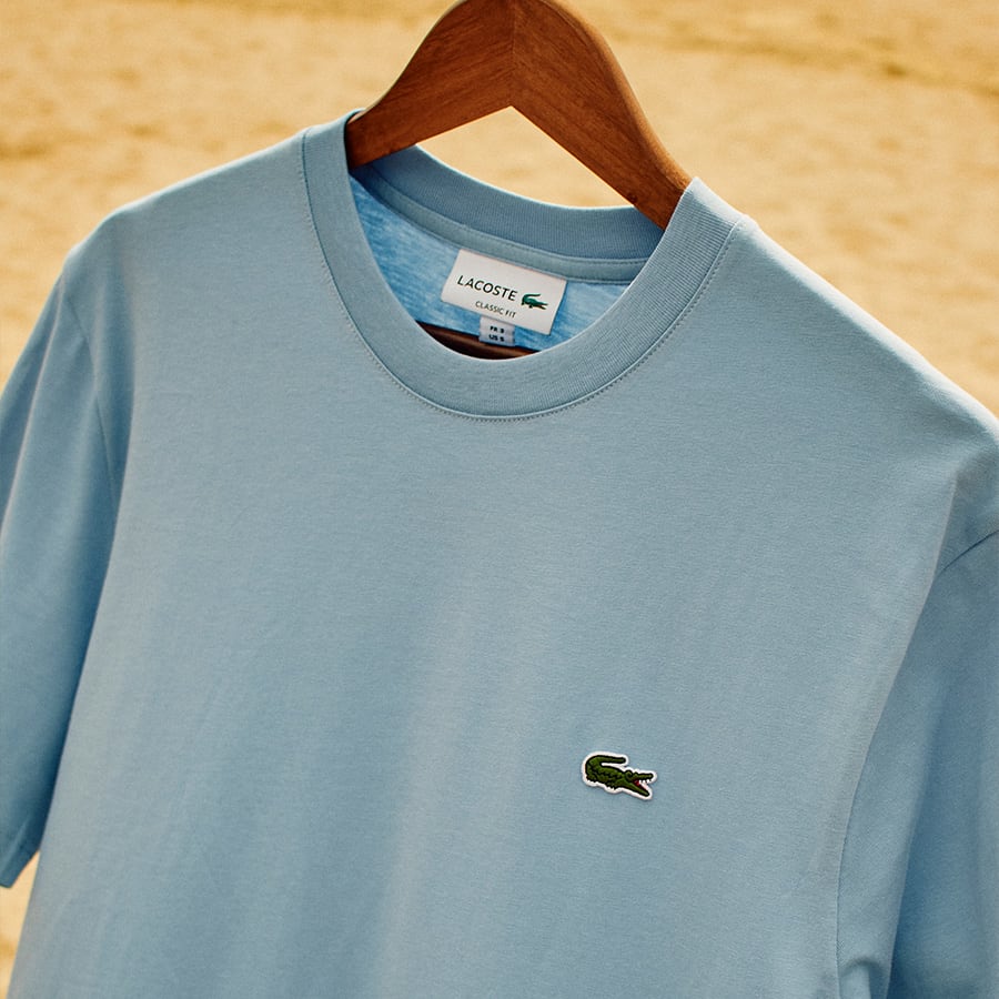 A blue Lacoste T-Shirt on a hanger
