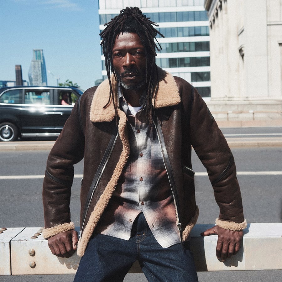 A man sitting in a city wearing Belstaff clothing