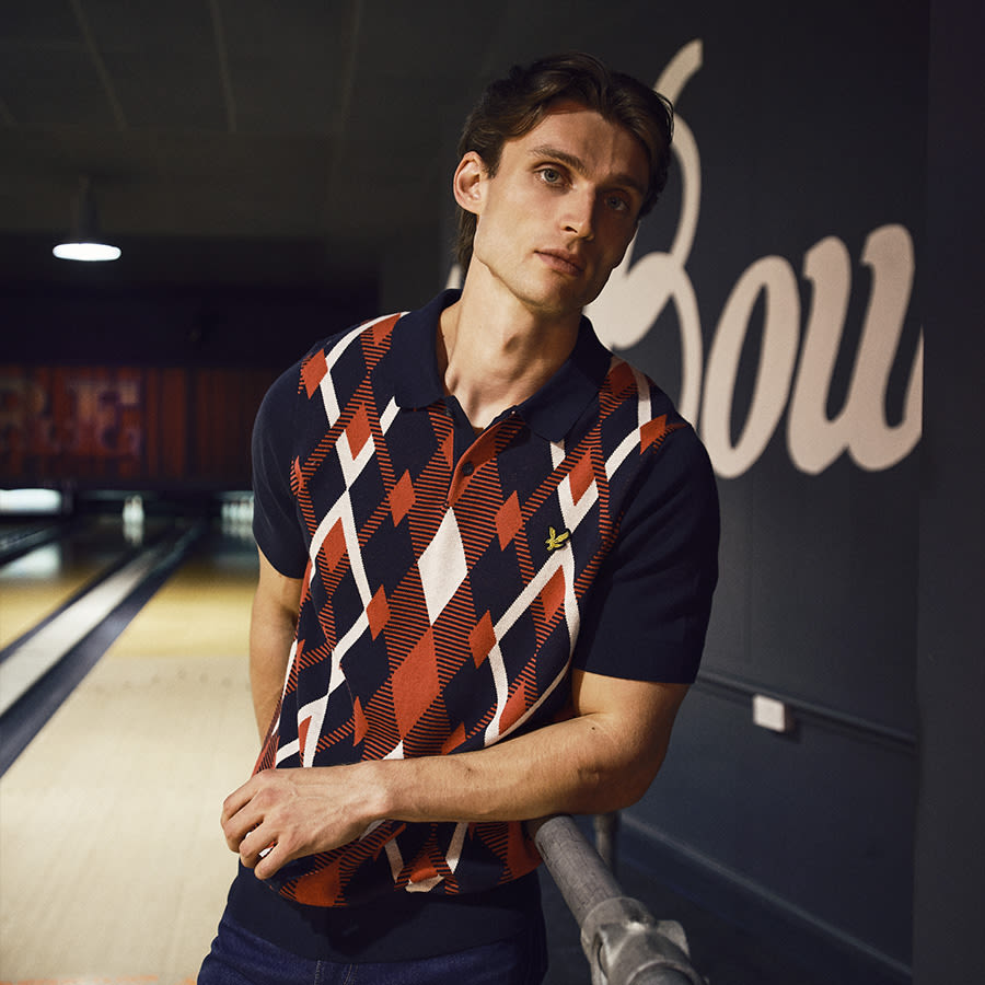 A man in a bowling alley wearing a Fred Perry polo shirt