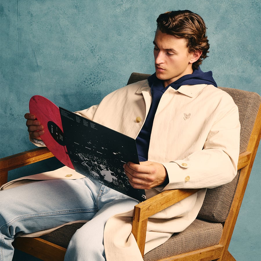 A man sitting down and looking at a record